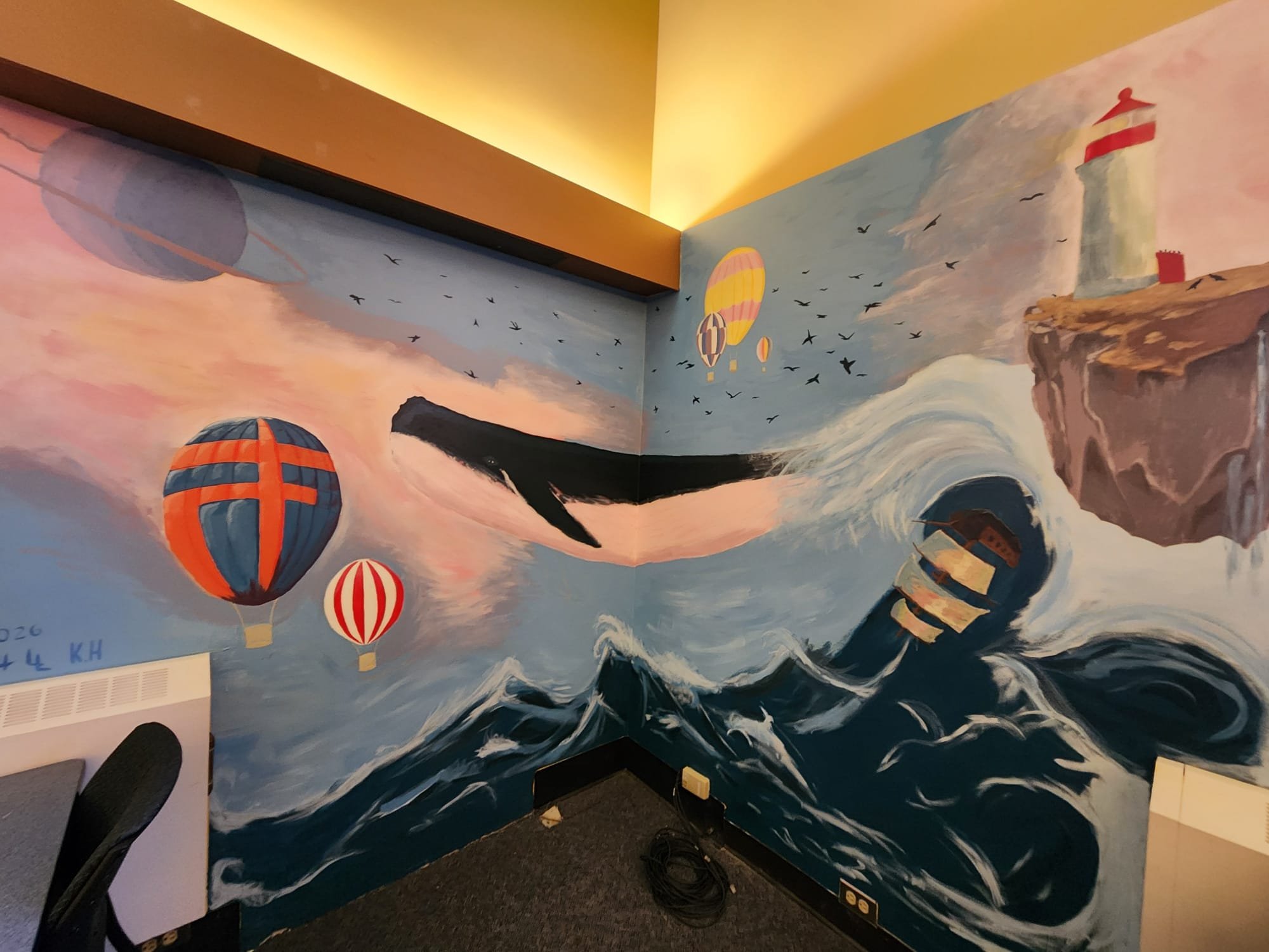 Whale mural painted across a room corner